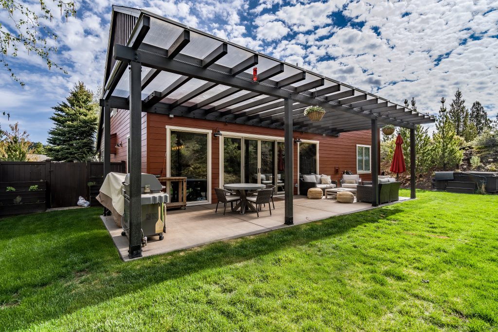 an outdoor room with pergola and patio pavers